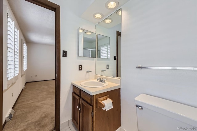 bathroom featuring toilet, visible vents, and vanity