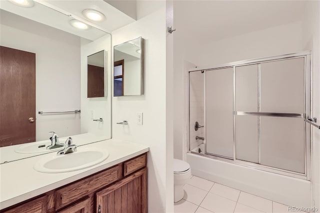 full bathroom featuring bath / shower combo with glass door, vanity, toilet, and tile patterned floors