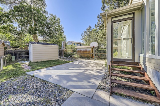 view of patio / terrace featuring entry steps, a fenced backyard, an outdoor structure, and a storage shed