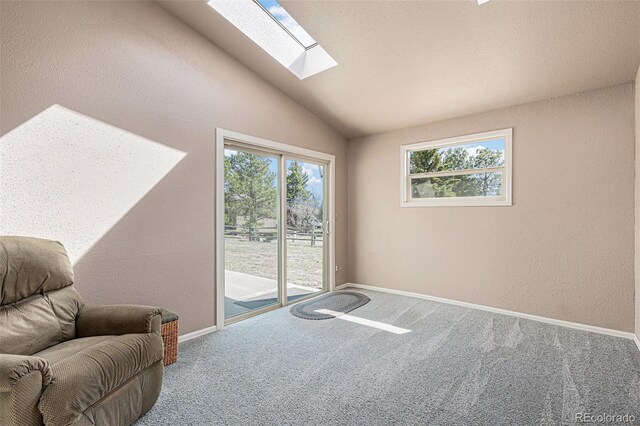 1095 Lake Woodmoor Dr, Monument, CO 80132 - sitting room with a skylight, carpet, vaulted ceiling, a textured wall, and baseboards
