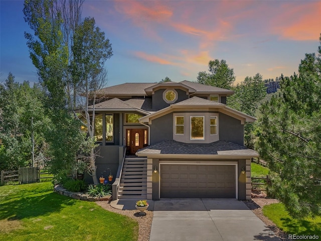 view of front of home featuring stucco siding, stairway, fence, a garage, and driveway