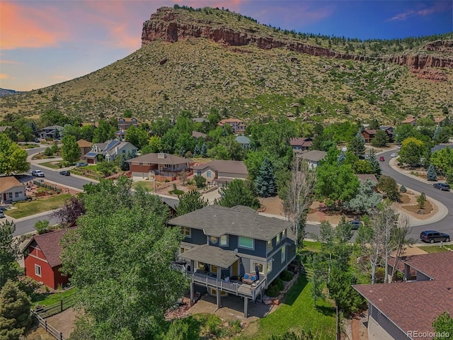 aerial view at dusk featuring a mountain view and a residential view