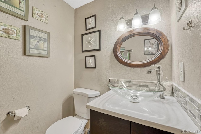 14034 E Utah Cir, Aurora, CO 80012 - bathroom featuring toilet, vanity, and a textured wall
