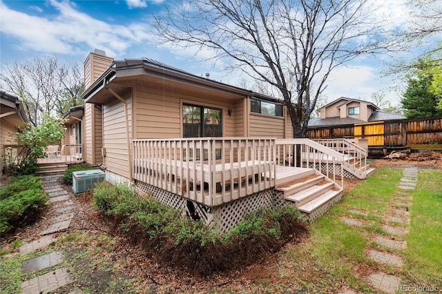 7500 E Dartmouth Ave Unit 16, Denver, CO 80231 - back of property featuring central AC, fence, a wooden deck, and a chimney
