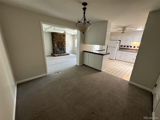 2991 S Whiting Way, Denver, CO 80231 - kitchen with freestanding refrigerator, ceiling fan, light colored carpet, and white cabinetry