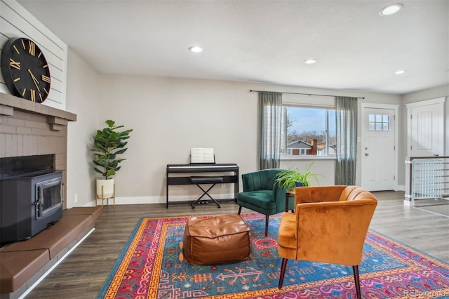living area with baseboards, wood finished floors, and recessed lighting