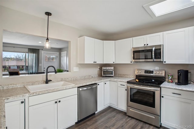 kitchen featuring dark wood finished floors, a sink, white cabinetry, and appliances with stainless steel finishes