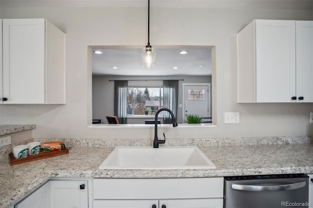 kitchen with dishwasher, light countertops, a sink, and white cabinets