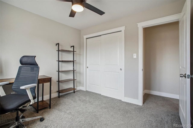 carpeted office featuring a ceiling fan and baseboards