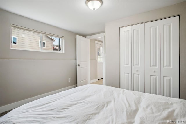 bedroom featuring baseboards and a closet
