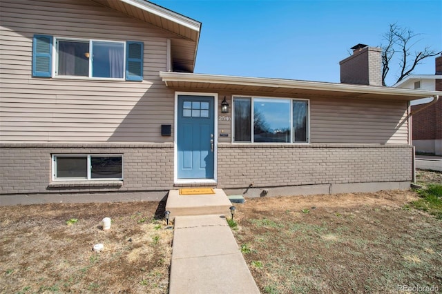 view of exterior entry featuring brick siding