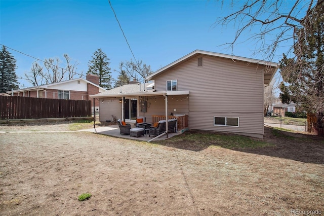 back of property featuring an outdoor hangout area, fence, and a patio area