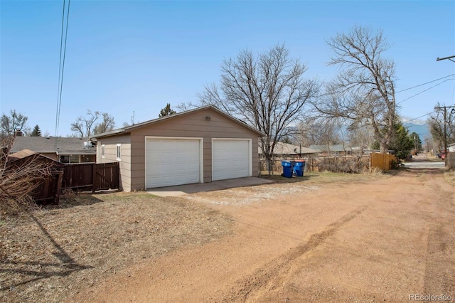 detached garage featuring fence