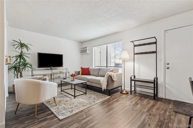 living room with dark hardwood / wood-style floors, a textured ceiling, and an AC wall unit