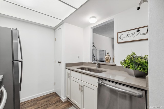 kitchen with white cabinetry, appliances with stainless steel finishes, dark hardwood / wood-style flooring, and sink