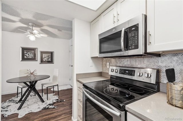 kitchen featuring tasteful backsplash, appliances with stainless steel finishes, dark hardwood / wood-style floors, and white cabinets