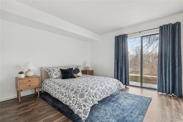 bedroom with access to exterior, dark hardwood / wood-style flooring, and a textured ceiling