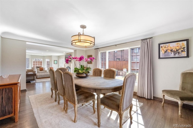 dining space featuring dark wood-style flooring, plenty of natural light, and baseboards