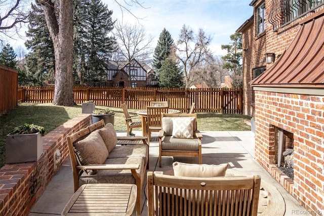 view of patio / terrace with an outdoor living space with a fireplace and a fenced backyard