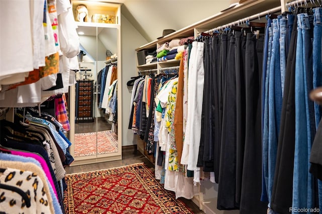 walk in closet with lofted ceiling and dark wood-style floors