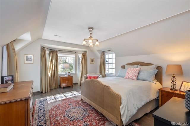 bedroom featuring lofted ceiling, visible vents, dark wood finished floors, and an inviting chandelier