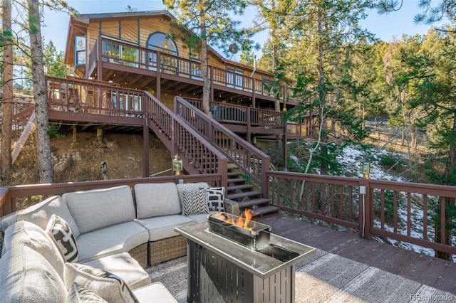 deck with an outdoor living space with a fire pit