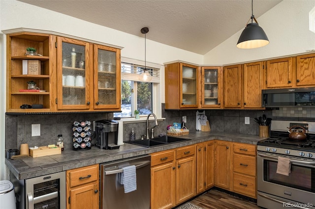 kitchen with wine cooler, sink, vaulted ceiling, stainless steel appliances, and decorative backsplash