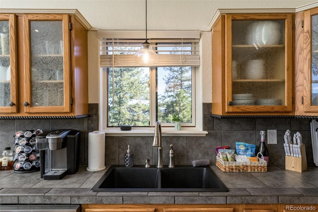 kitchen featuring tasteful backsplash, sink, and hanging light fixtures