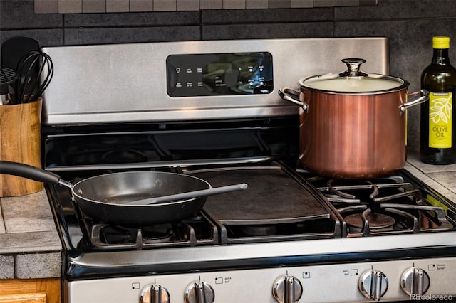 interior details with gas range and decorative backsplash