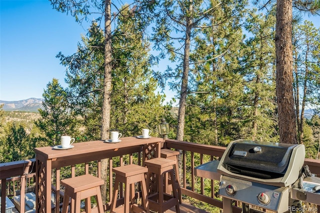 wooden deck featuring a mountain view and grilling area