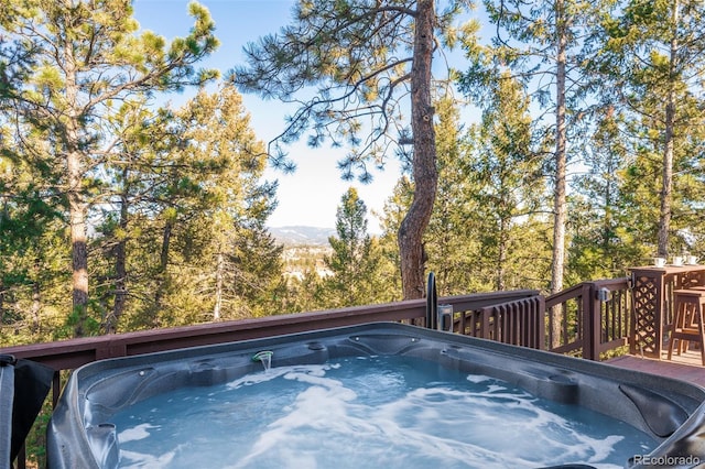 view of pool featuring a hot tub and a deck with mountain view