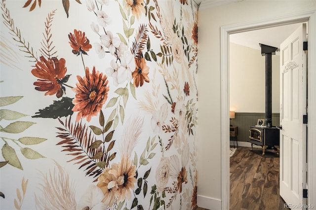 bathroom with hardwood / wood-style flooring, ornamental molding, and a wood stove