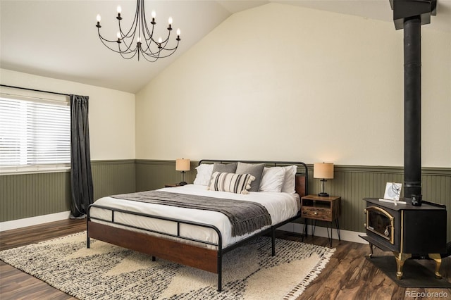 bedroom featuring vaulted ceiling, a wood stove, and dark hardwood / wood-style flooring