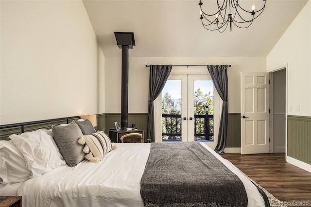 bedroom with lofted ceiling, dark wood-type flooring, access to exterior, french doors, and a wood stove