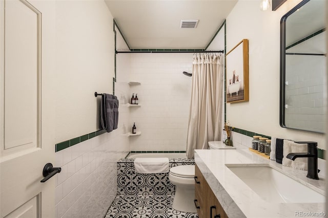 bathroom with tile walls, vanity, a shower with curtain, tile patterned floors, and toilet