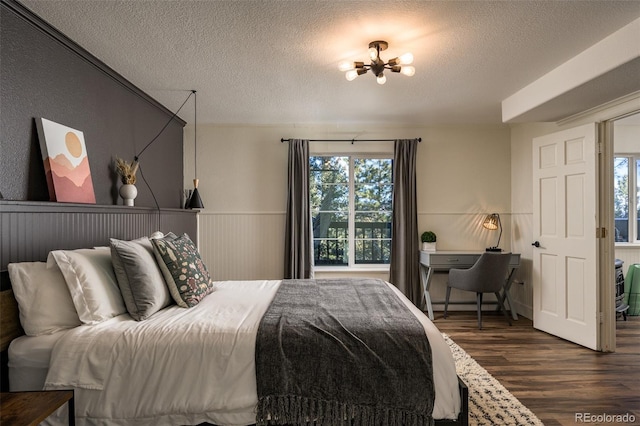 bedroom with a chandelier, dark hardwood / wood-style floors, and a textured ceiling