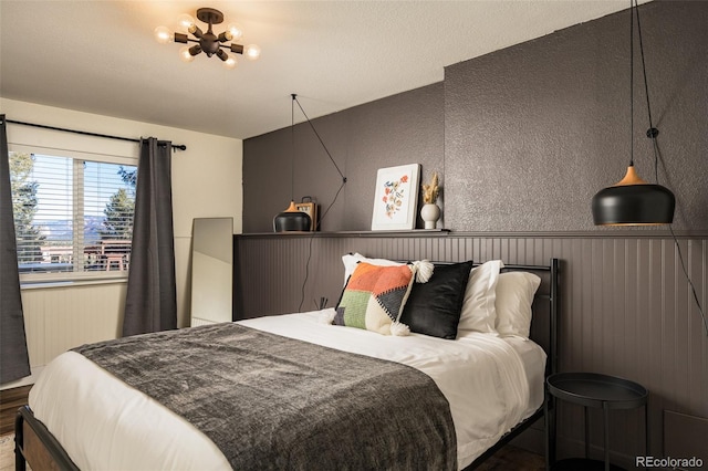 bedroom with hardwood / wood-style flooring and a chandelier