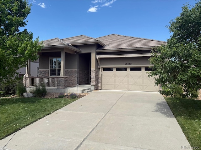 15852 Lavender Pl, Broomfield, CO 80023 - prairie-style home with covered porch, an attached garage, stucco siding, concrete driveway, and a front lawn