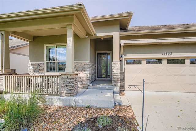 15852 Lavender Pl, Broomfield, CO 80023 - entrance to property featuring stucco siding, stone siding, a garage, and driveway