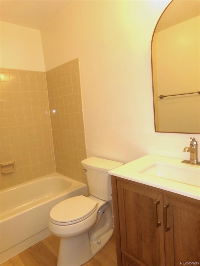 full bathroom with hardwood / wood-style floors, vanity, toilet, and tiled shower / bath combo