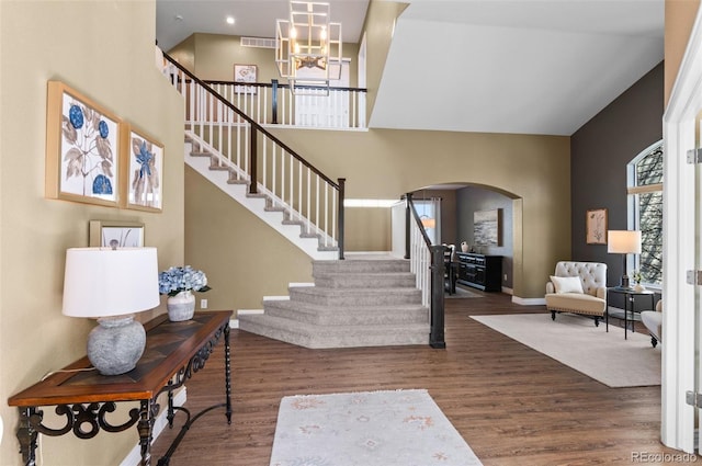 11991 Hazy Hills Dr, Parker, CO 80138 - entrance foyer featuring a chandelier, arched walkways, stairway, and wood finished floors