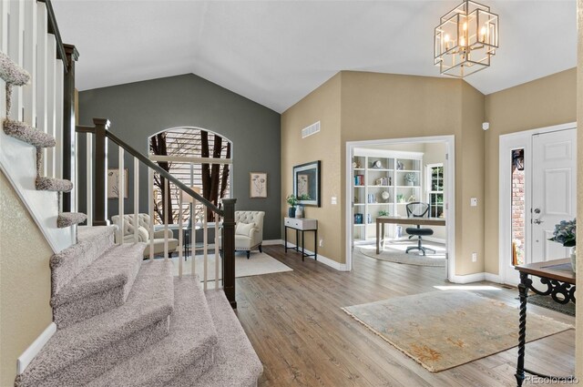 11991 Hazy Hills Dr, Parker, CO 80138 - entryway with visible vents, a notable chandelier, stairway, wood finished floors, and lofted ceiling
