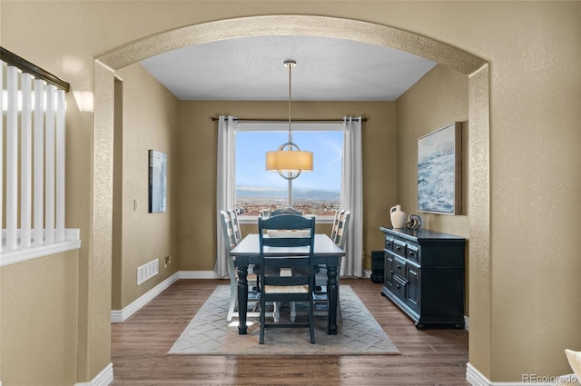 11991 Hazy Hills Dr, Parker, CO 80138 - dining room with visible vents, baseboards, arched walkways, a textured wall, and dark wood-type flooring