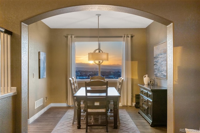 11991 Hazy Hills Dr, Parker, CO 80138 - dining area with dark wood-style flooring, visible vents, and arched walkways