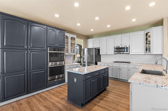 11991 Hazy Hills Dr, Parker, CO 80138 - kitchen with recessed lighting, a kitchen island, white cabinets, appliances with stainless steel finishes, and a sink