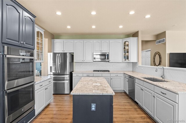 11991 Hazy Hills Dr, Parker, CO 80138 - kitchen featuring glass insert cabinets, a kitchen island, visible vents, appliances with stainless steel finishes, and a sink