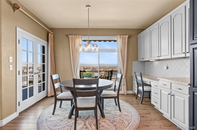 11991 Hazy Hills Dr, Parker, CO 80138 - dining area with baseboards, light wood finished floors, and a notable chandelier
