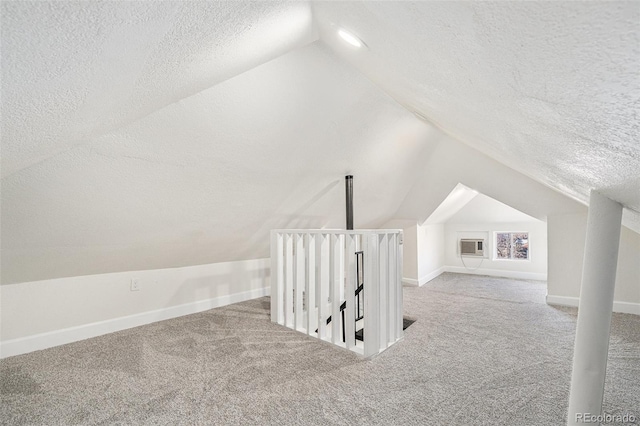 bonus room featuring a textured ceiling, vaulted ceiling, carpet floors, and baseboards