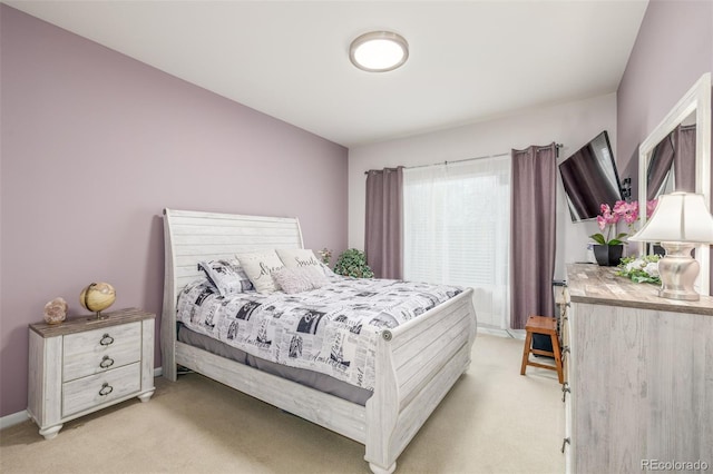 bedroom with light colored carpet and baseboards