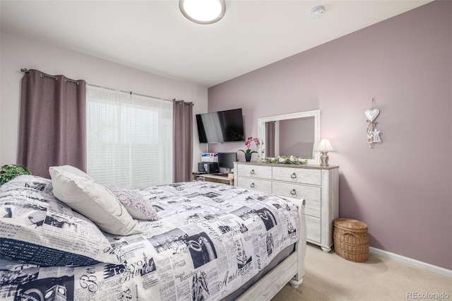 bedroom with light colored carpet and baseboards